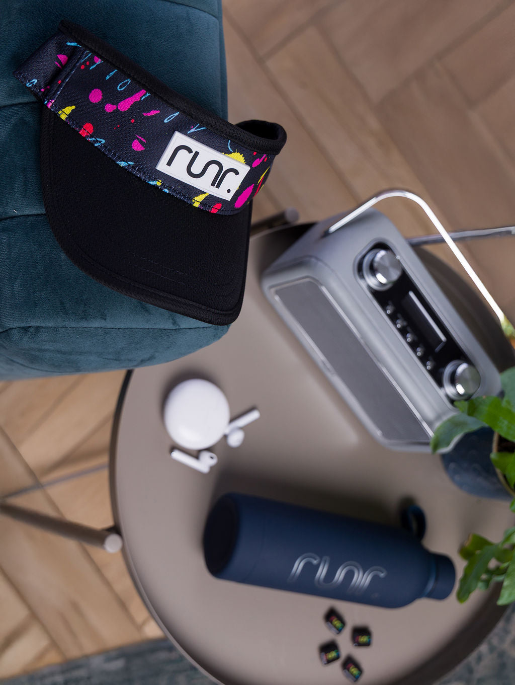 Black running visor with multicolor splatter band and 'runr' logo patch