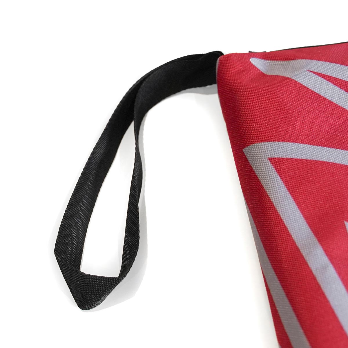 Guidebook cover corner detail with red fabric, white angular print, black strap