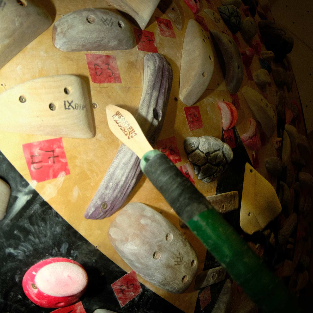 Boar-hair climbing brush resting among climbing holds and chalked gear
