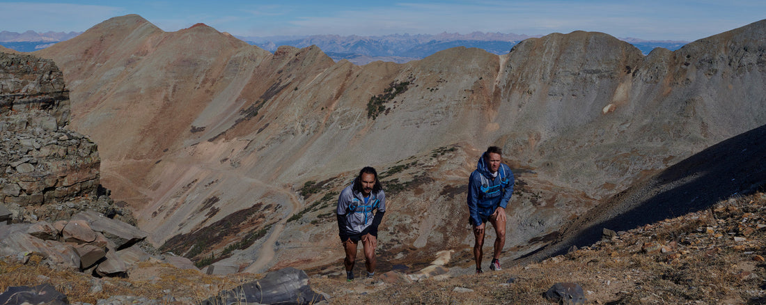 Trail runner ascending a steep mountain path in technical terrain