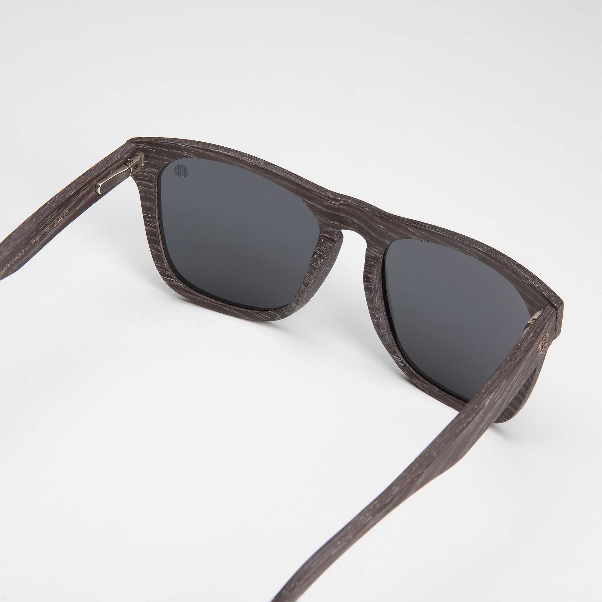 Polarized sunglasses, dark woodgrain frame and dark mirrored lenses.