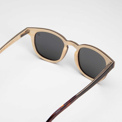 Beige-and-brown sunglasses with dark lenses and angled frame