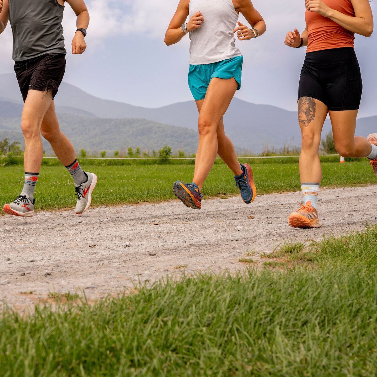 No-show merino running socks on runners’ feet, light-colored knit socks
