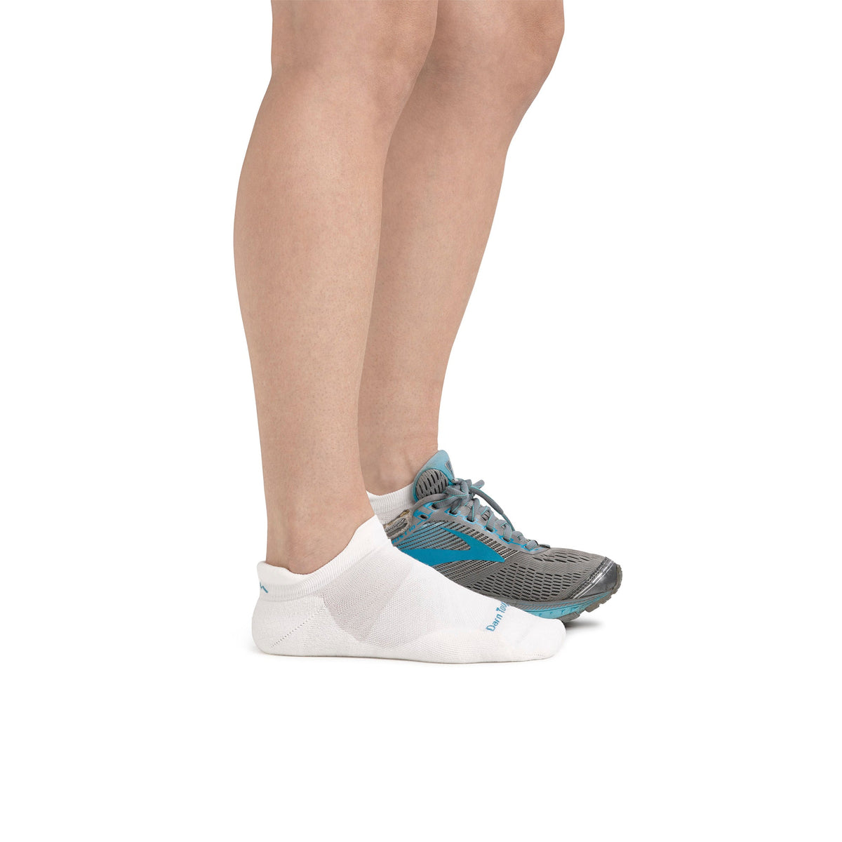 No-show merino running socks on foot, white knit with heel logo