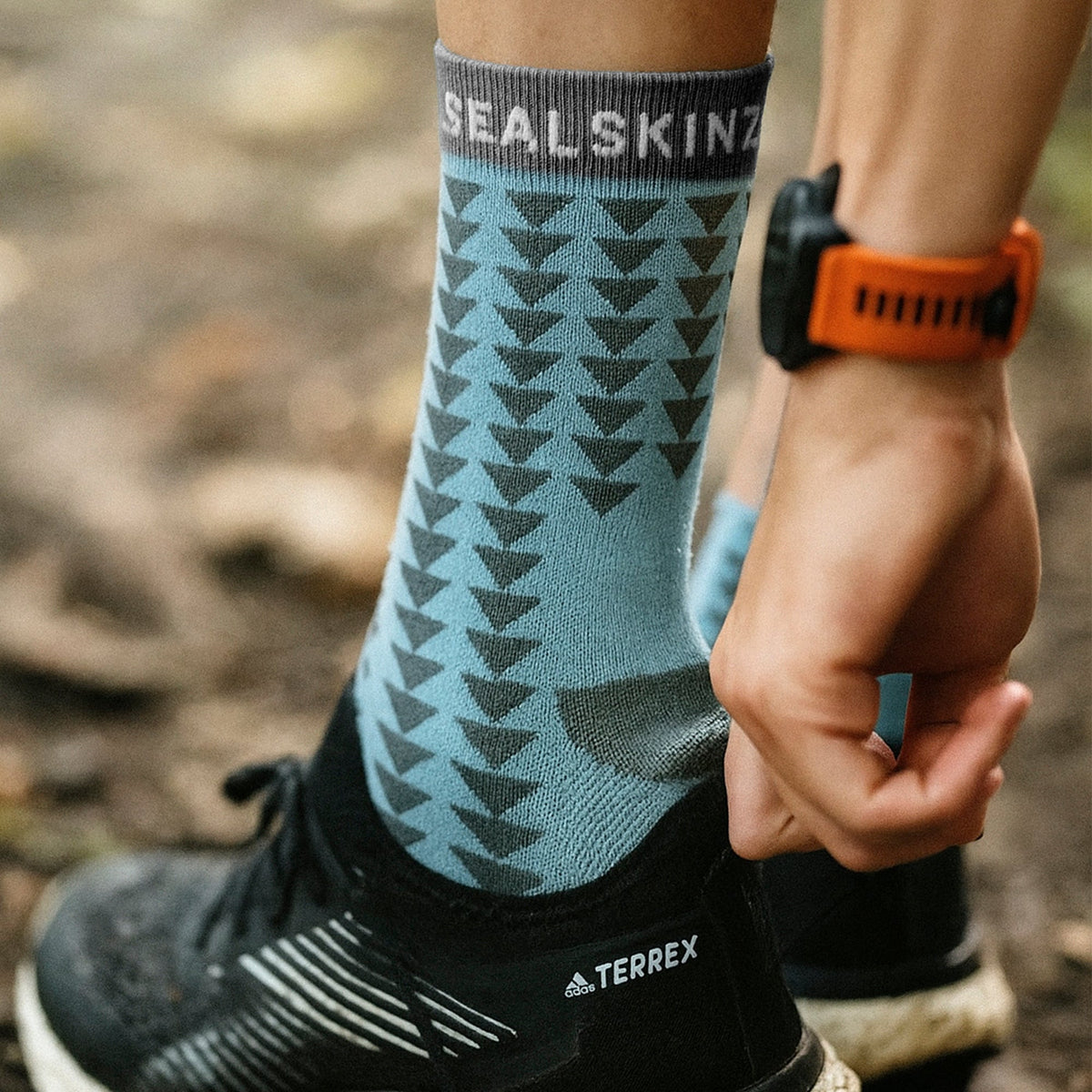 Mid-length running socks, teal with dark triangular pattern; gray toe and heel.
