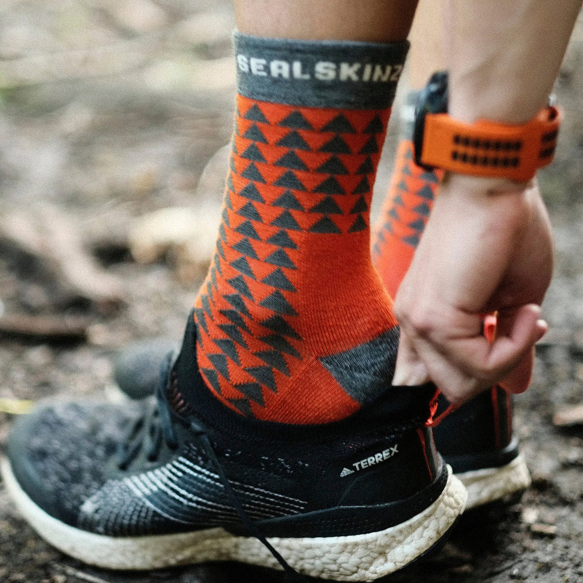 Mid-length running socks, orange with dark triangular pattern; gray toe and heel.