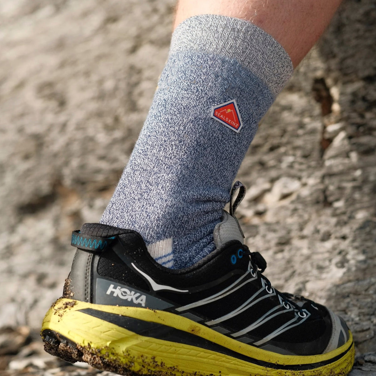 Mid-length hiking socks in blue with striped heel and orange toe; worn with trail shoes