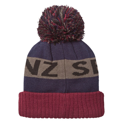 Navy knit beanie with burgundy cuff, grey bobble, and stripe reading "NZ S" plus leather patch