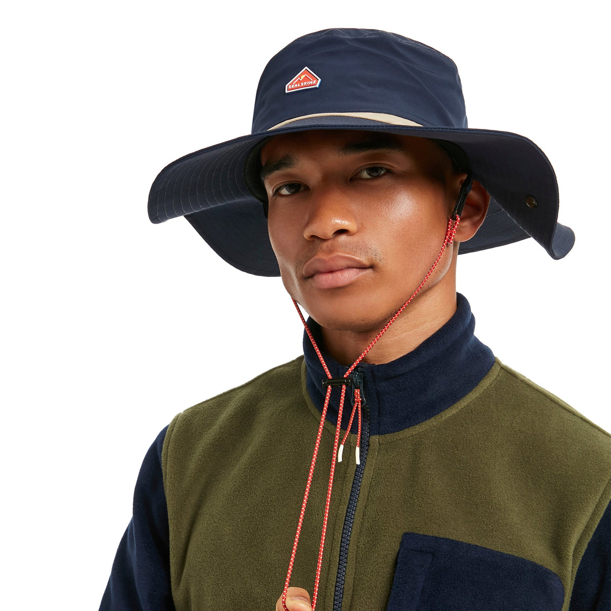 Navy boonie hat worn by model with chin cord and red logo patch, wide brim