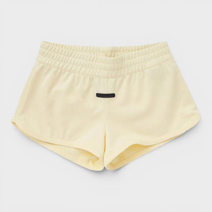 Adidas pale yellow athletic shorts with elastic waistband and small front logo