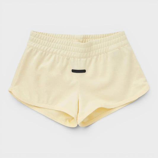 Adidas pale yellow athletic shorts with elastic waistband and small front logo