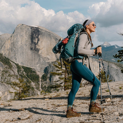 Teal merino hiking socks with bear pattern worn by hiker with trekking poles