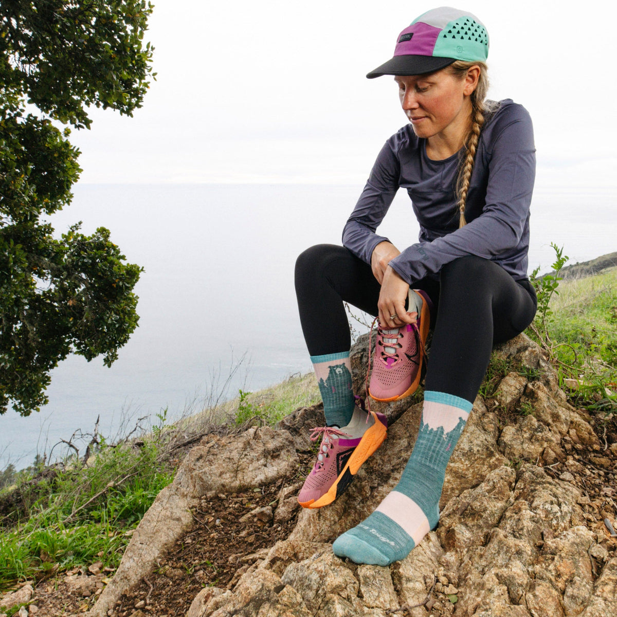 Merino hiking socks with teal legs, light pink toes, and bear graphic