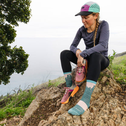 Merino hiking socks with teal legs, light pink toes, and bear graphic
