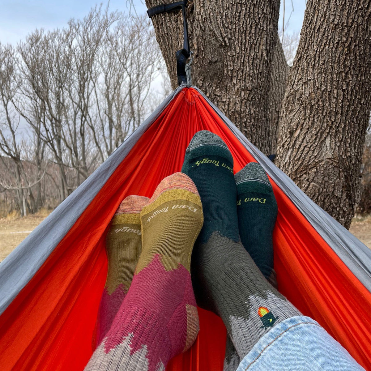 Hiking crew socks in mixed colors—teal, tan, and red—stacked for travel