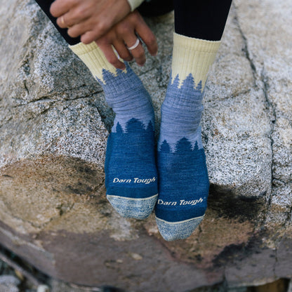 Ladies crew hiking socks in light denim blue with tree graphic and “Darn Tough” text.