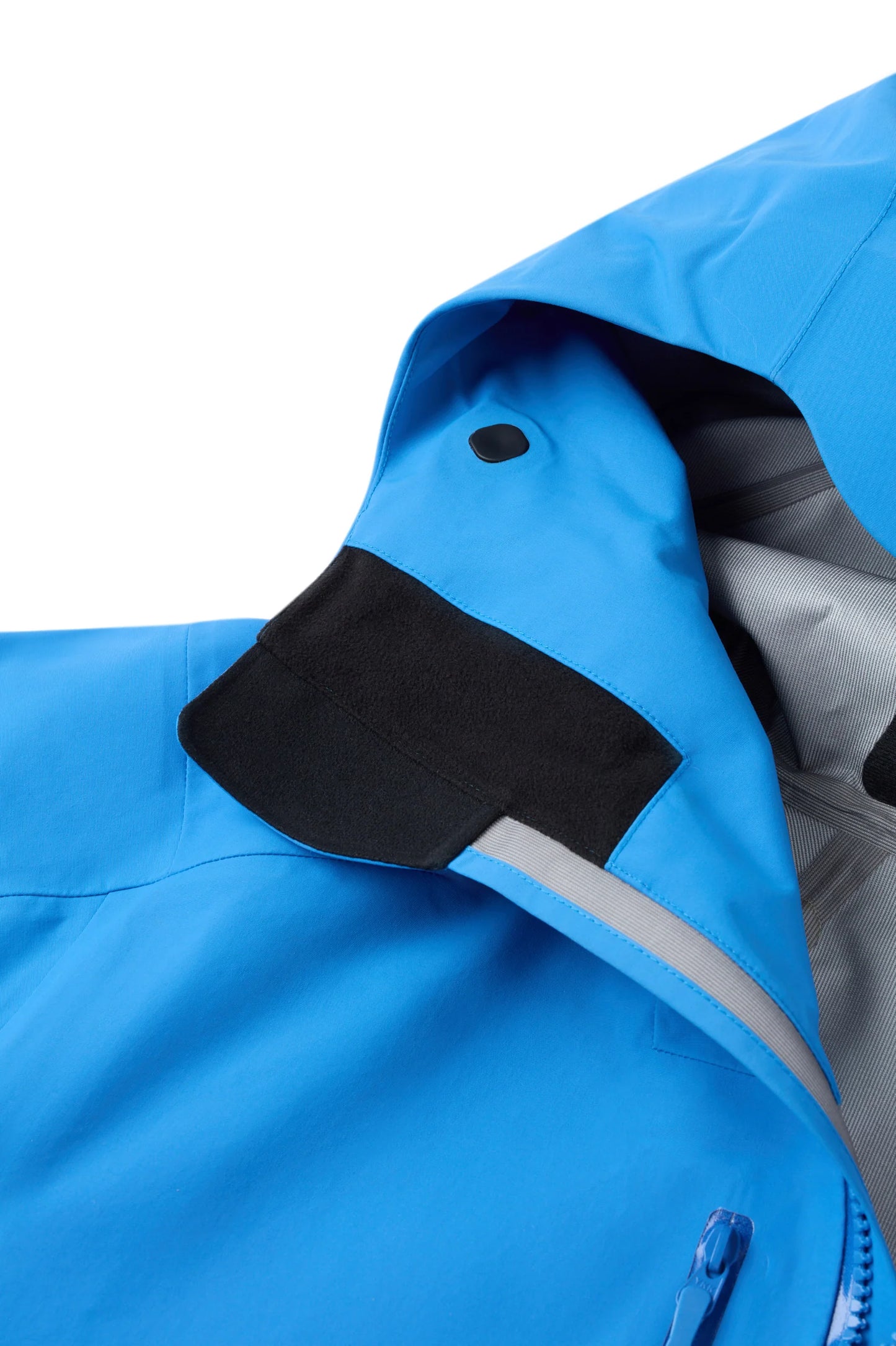 Hooded shell jacket shoulder with black collar patch and blue hood underside