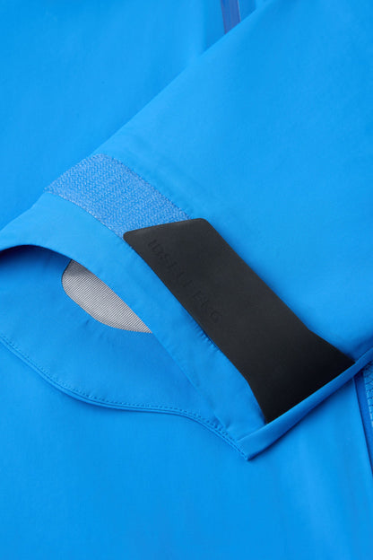 Blue shell jacket, close-up of side seam and black inner label