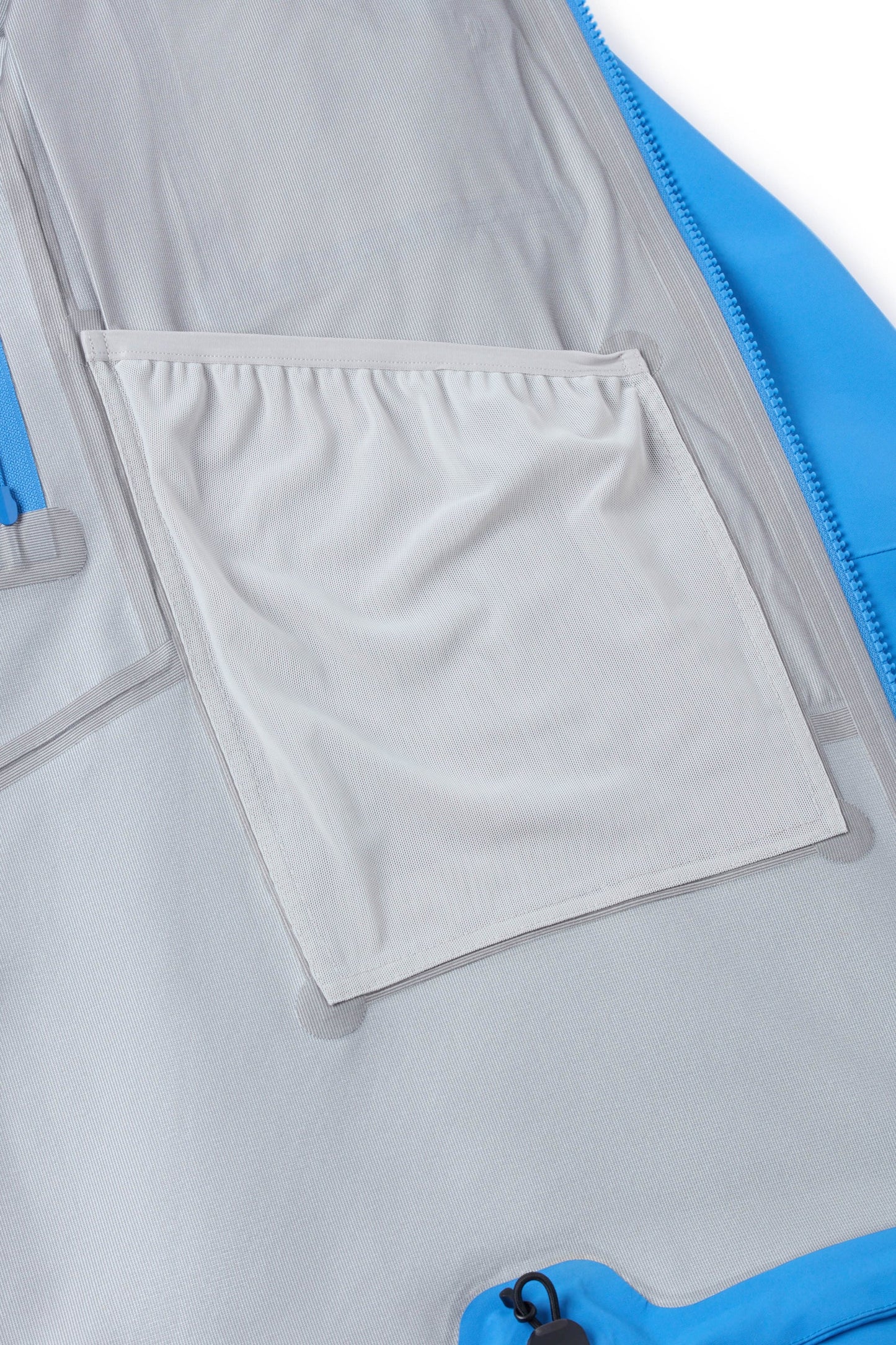 Hooded shell jacket interior pocket panel with adjustable tabs, light gray
