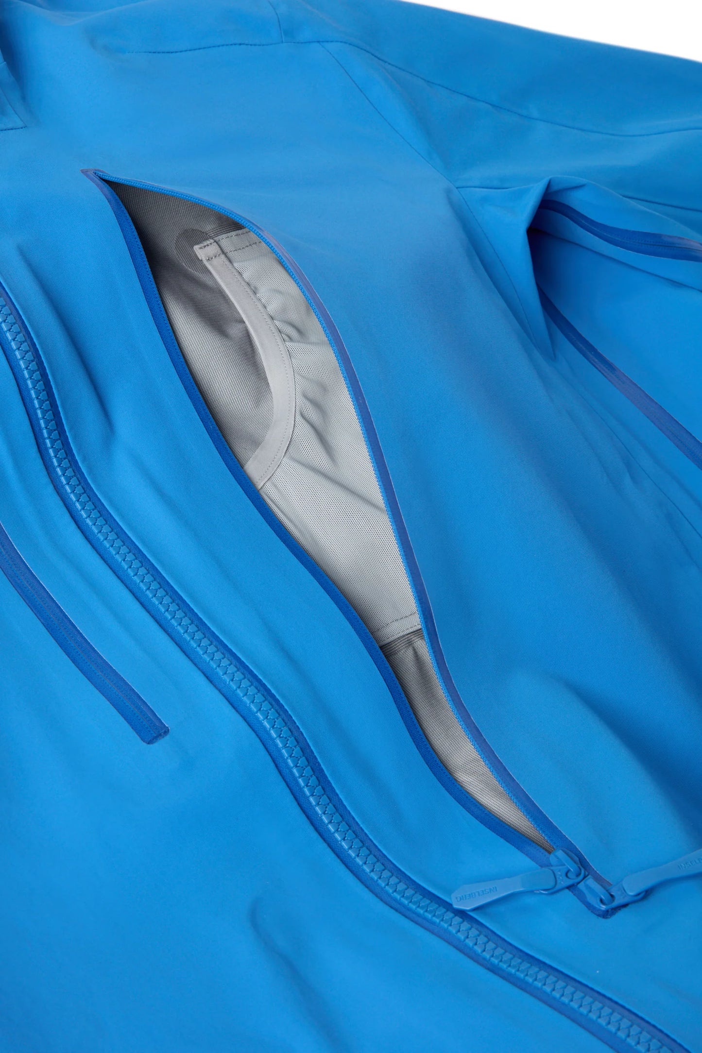 Hooded shell jacket side zip opening with light gray inner lining and zipper track