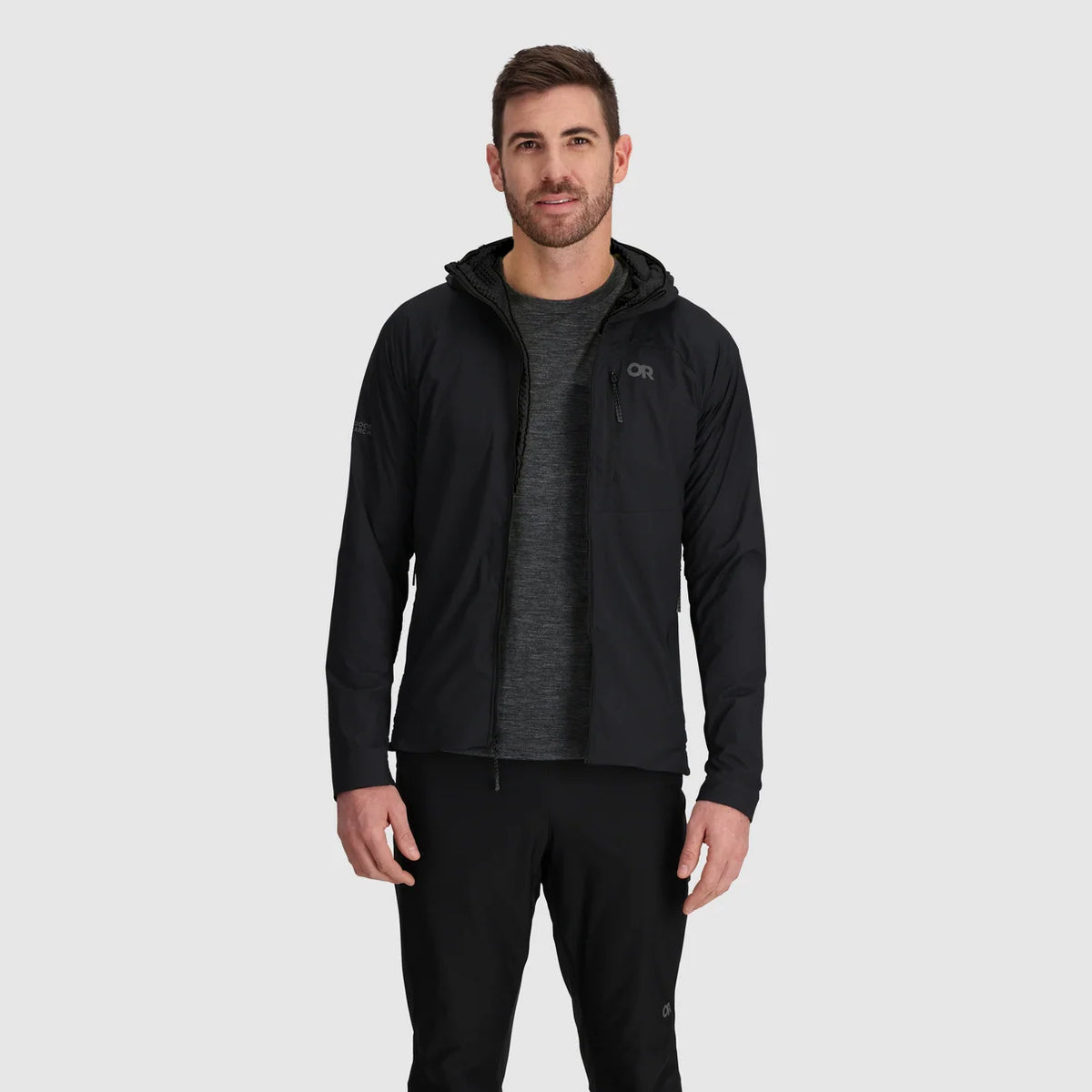 Man wearing an open black hoodie over a gray shirt