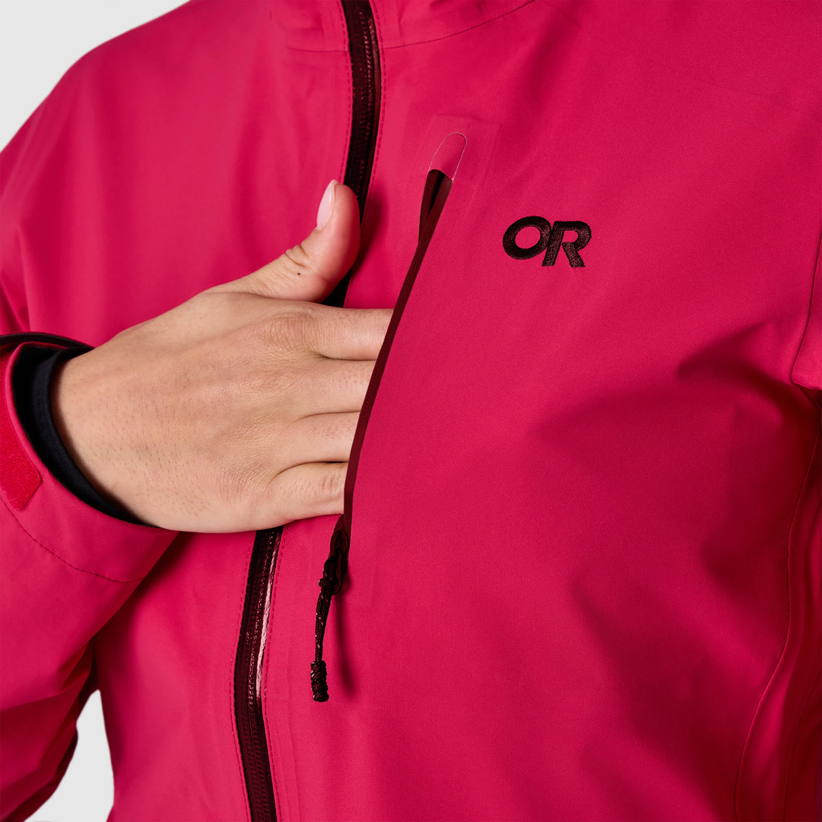 Red rain jacket chest pocket with vertical zipper and OR logo