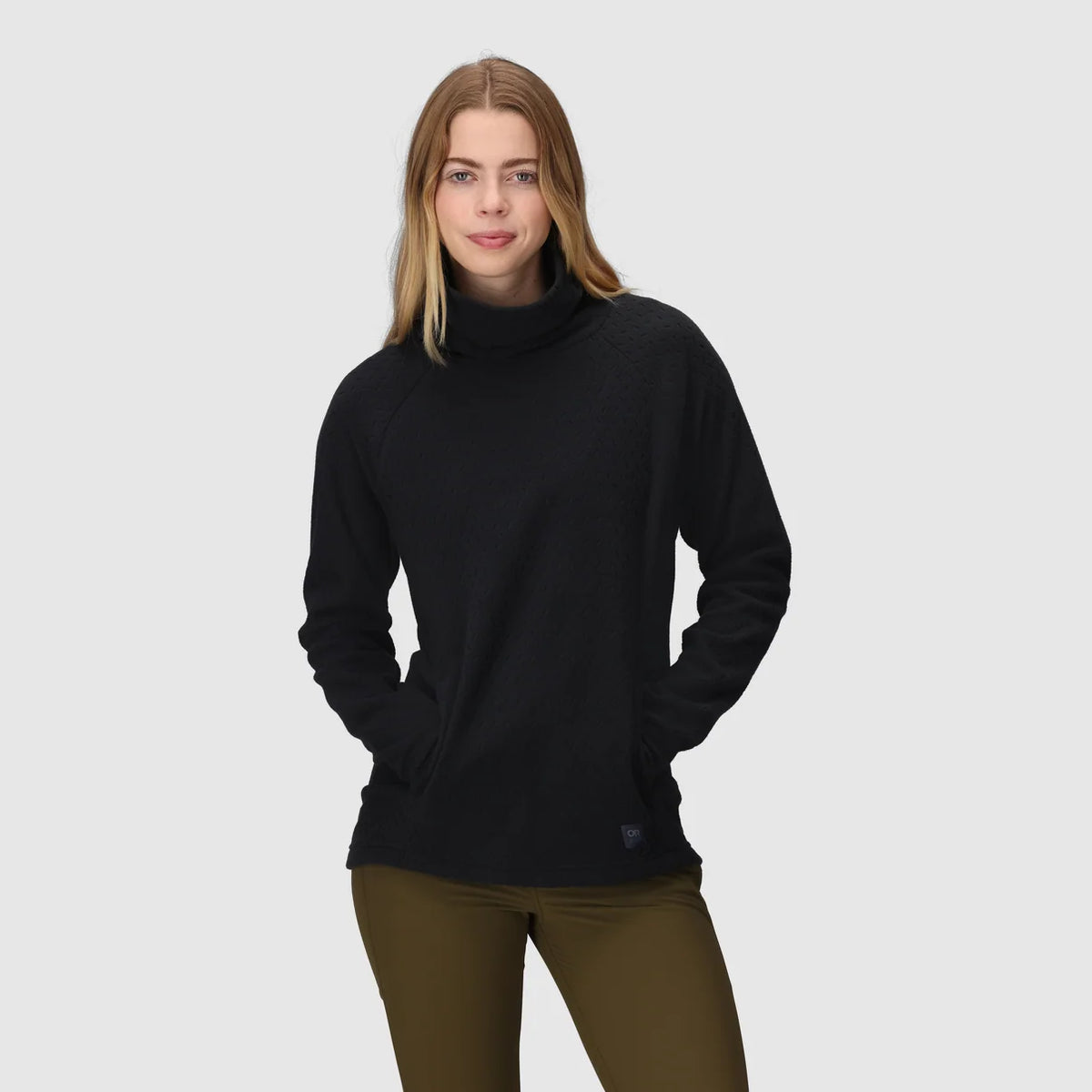 Black fleece cowl pullover with front pockets, worn with hands tucked inside