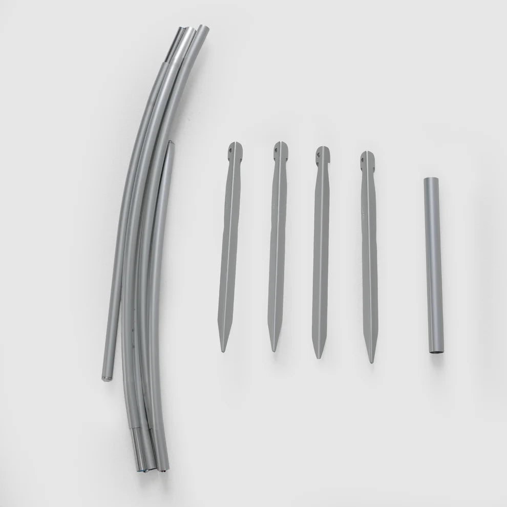 Bivy shelter pole segments and four gray stakes laid out