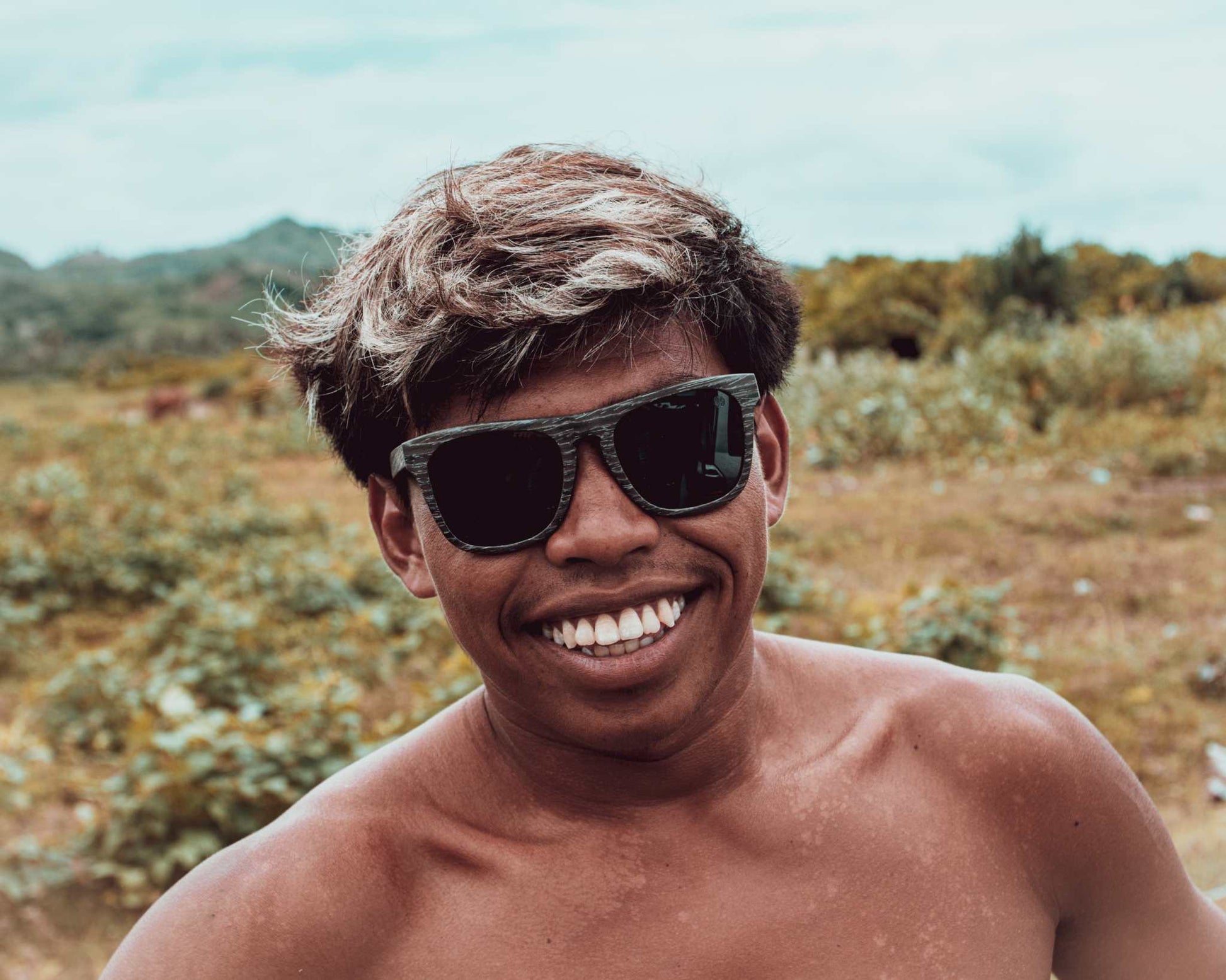 Dark sunglasses on smiling person outdoors
