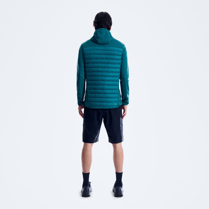 Person wearing a teal puffer jacket on a white background