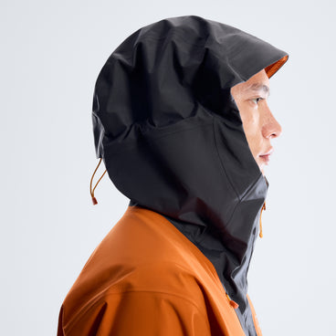 Hood detail on orange and black rain jacket with adjustable drawcord