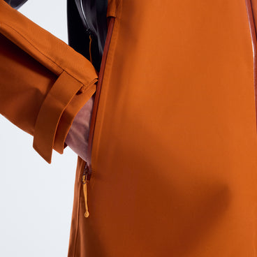 Orange rain jacket sleeve cuff with elastic hem and adjustable tab at the wrist