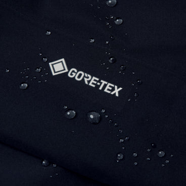 GORE-TEX logo on black waterproof fabric with visible water droplets