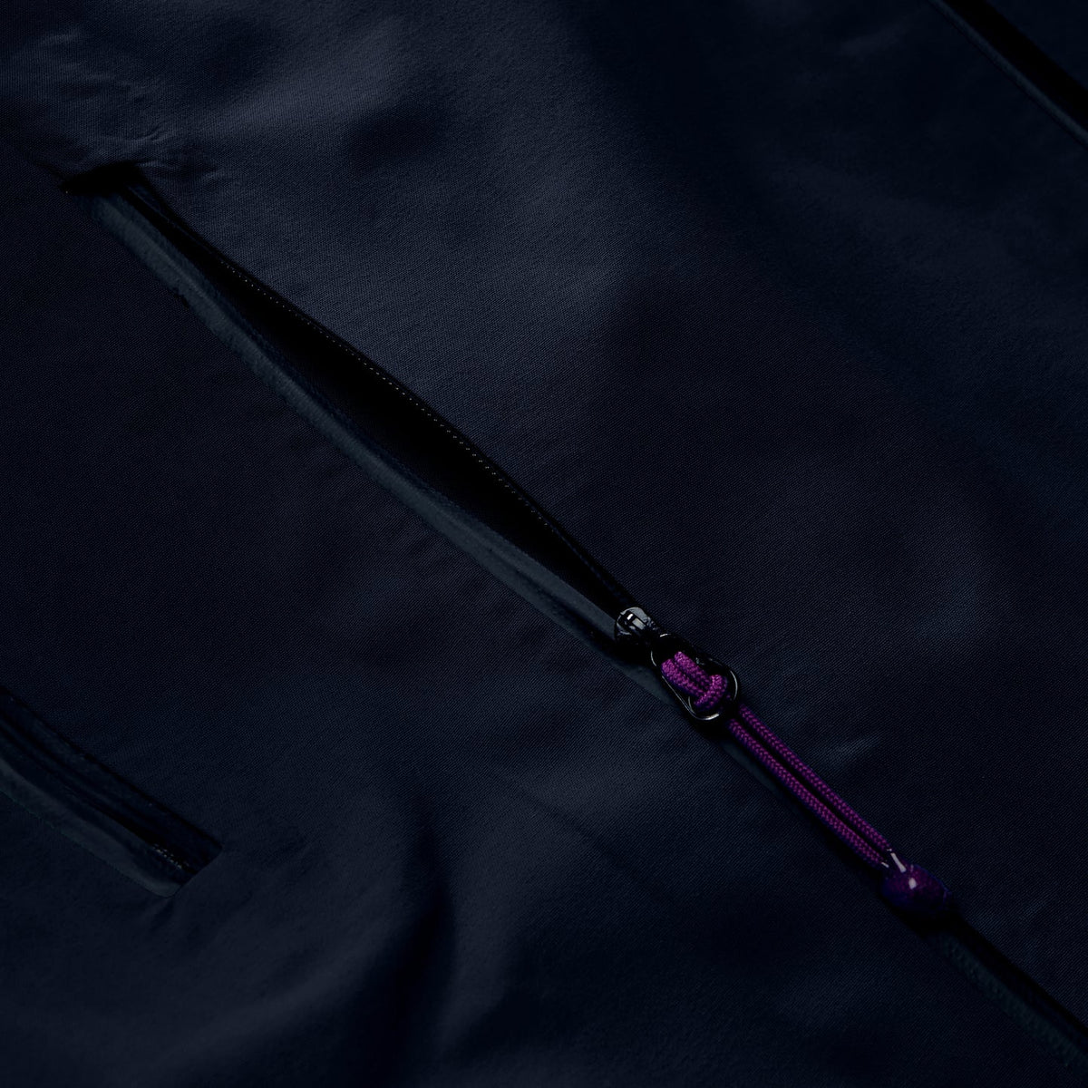 Black jacket fabric with diagonal purple zipper and pull tab