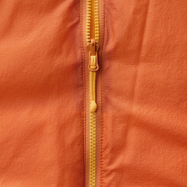 Orange insulated jacket close-up of full-zip with yellow zipper pull