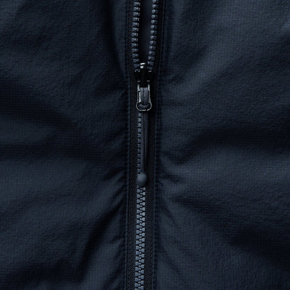Reversible insulated gilet close-up of full-length zipper teeth and pull.