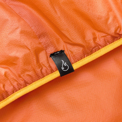 Orange gilet interior close-up with black brand label and flame logo on seam