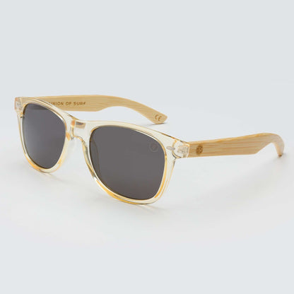 Clear and gold-tone cat-eye sunglasses with dark lenses and bamboo-look arms
