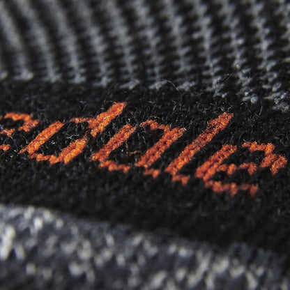 Black merino crew sock knit with orange stitch logo on fabric