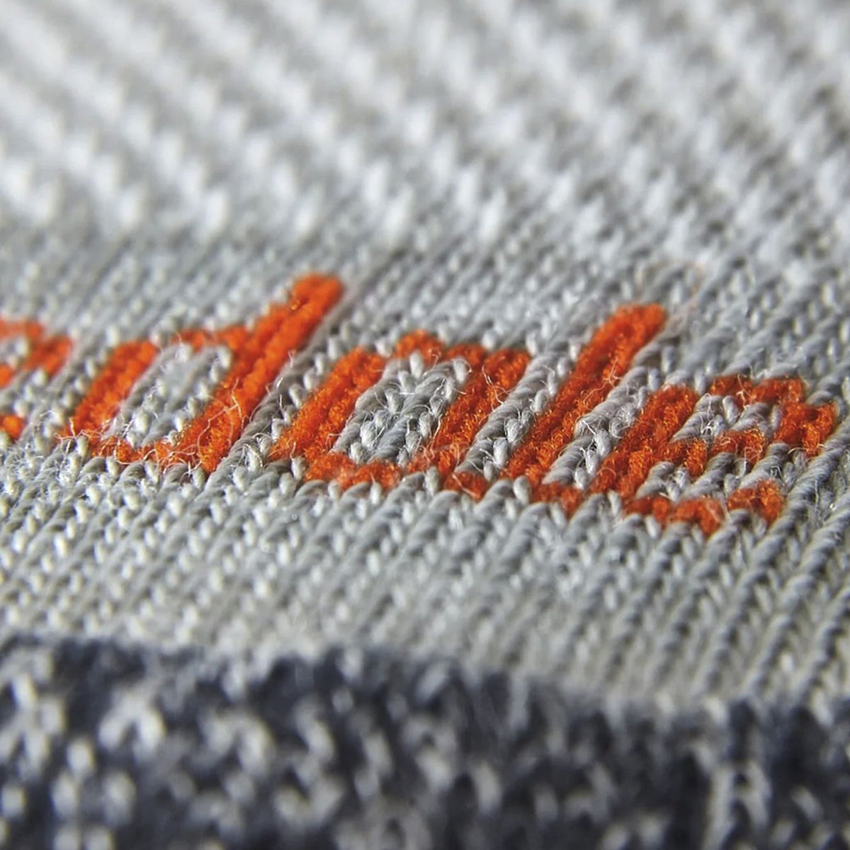 Light gray merino crew sock knit with orange stitch logo embroidery
