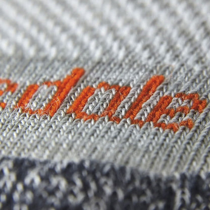 Light gray merino crew sock knit with orange stitch logo embroidery