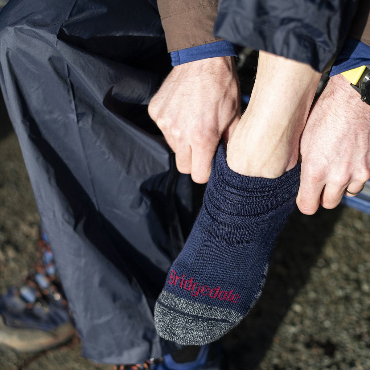 Navy hiking socks with red Bridgedale logo and cushioned heel-toe, worn with boots