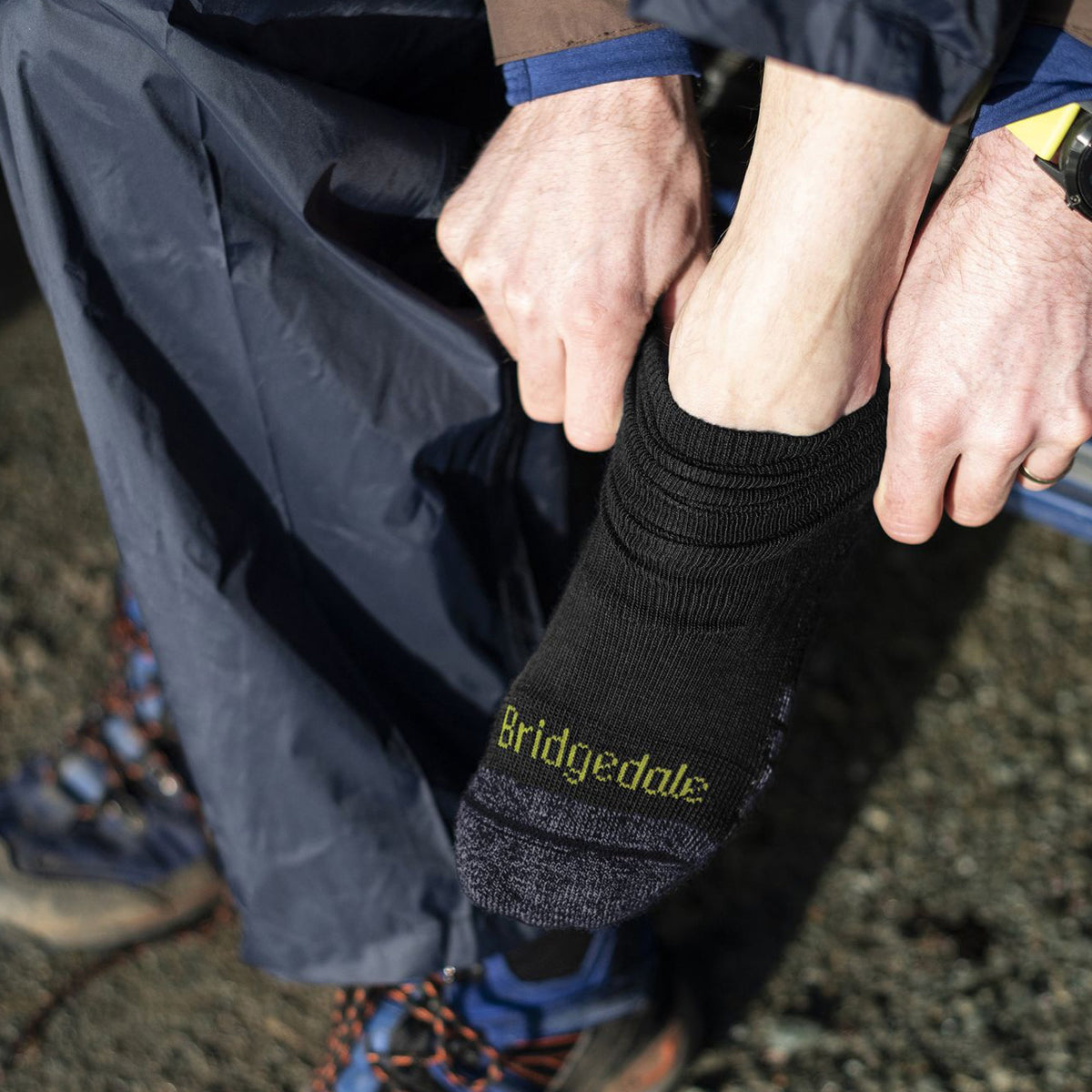 Black hiking socks with lime Bridgedale logo and cushioned heel-toe, worn with boots