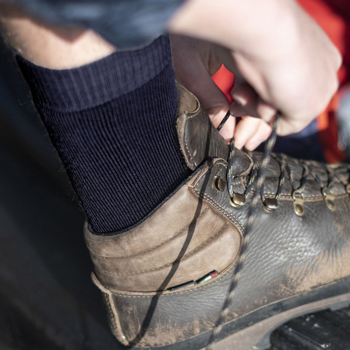 Navy merino wool crew socks on hiking boot, cushioned heel and toe