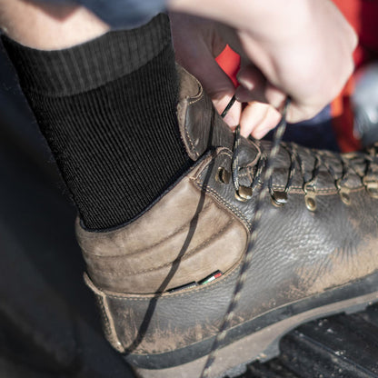 Black merino wool crew socks on hiking boot, cushioned heel and toe