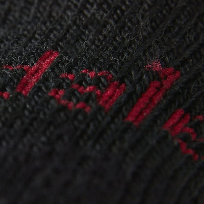 Close-up of black sock knit with red logo lettering