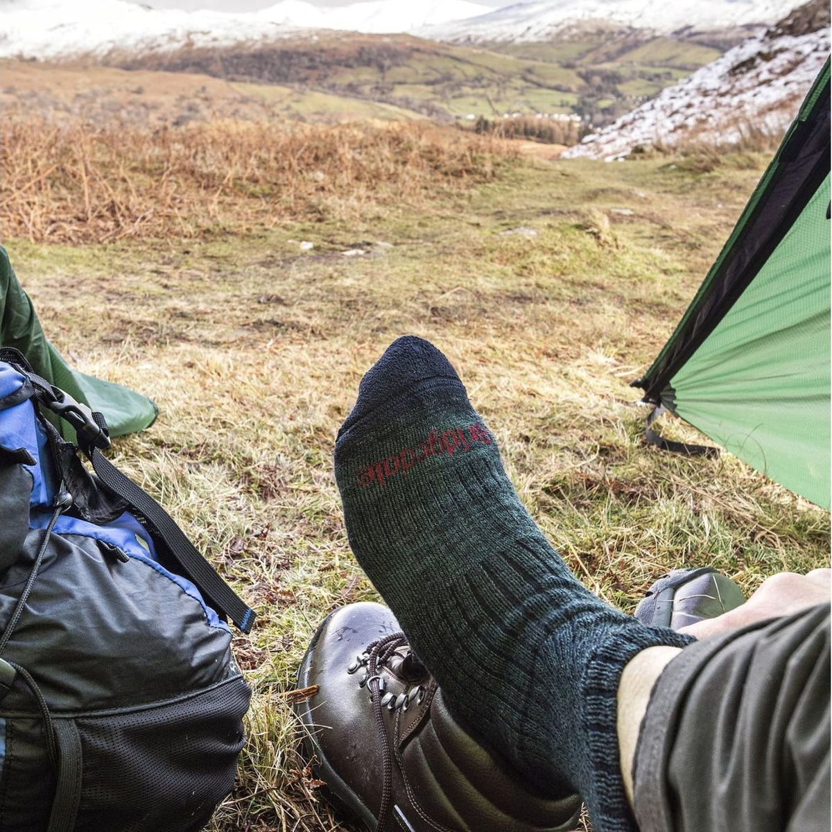 Men's mid-calf hiking boot sock on foot, dark gray knit with ribbed cuff