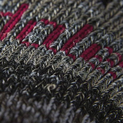 Close-up of textured merino wool sock knit in dark gray with red accent stripes