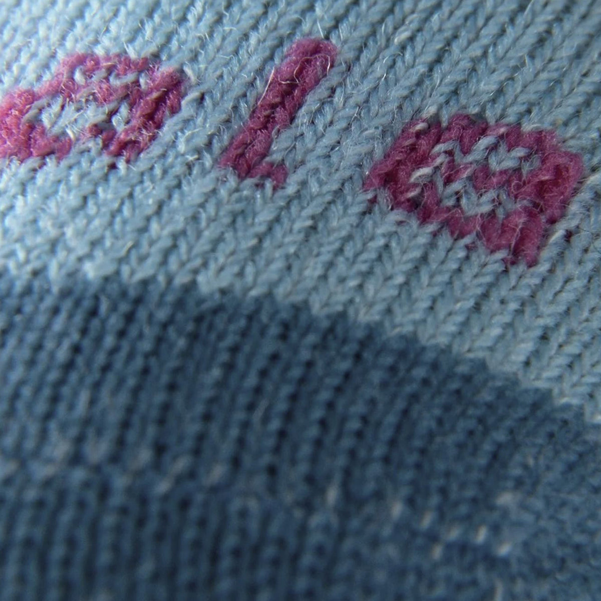 Light blue knit sock fabric with pink-red and blue embroidered logo detail