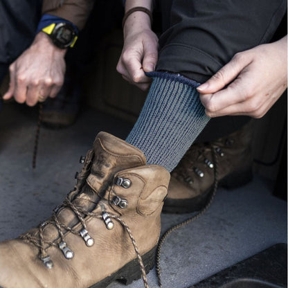 Ladies blue merino wool boot socks on hiking boots, with ribbed mid-calf cuff
